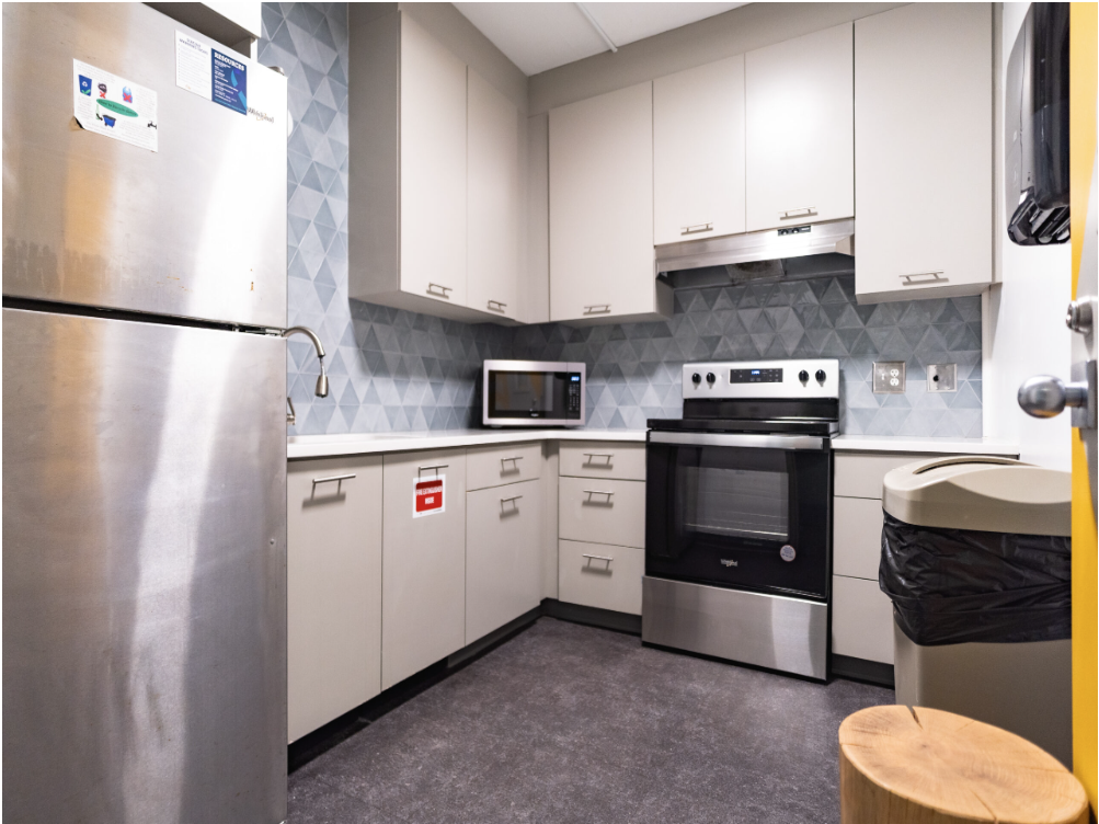Photo of Woodruff North kitchen that has white cabinets and countertops, a stainless steel fridge, and a microwave and stove.